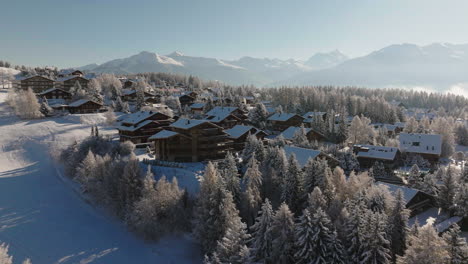 Aerial-shot-in-Switzerland-over-cabins-the-town-of-Crans-Montana,-Valais