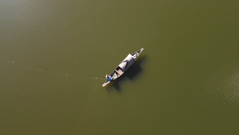 Luftaufnahme-Von-Fischern,-Die-Fische-Mit-Einem-Fischernetz-Am-Boot-Im-Fluss-Mit-Grünlichem-Wasser-In-Bangladesch-Fangen