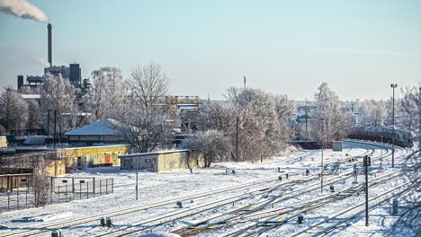 Time-lapse-shot-of-industrial-train-driving-into-factory-building-during-snowy-winter-day