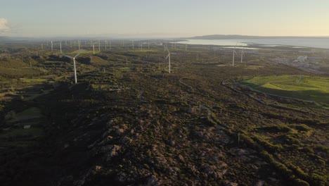 Static-aerial-drone-view-of-Wind-turbines-farm-at-golden-hour,-vast-landscape