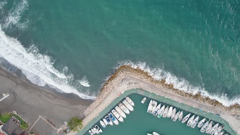 Aerial-top-down-view-of-a-beach-in-Candado-Beach,-Málaga,-Spain-with-a-dock-nearby