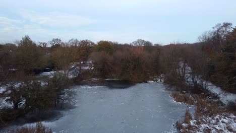 Drohne-Fliegt-Bei-Kaltem-Winterwetter-über-Gefrorenen-Teich-Mit-Schnee-Und-Eis