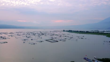 Aerial-view-of-many-fish-cages-on-the-lake-with-sunrise-sky