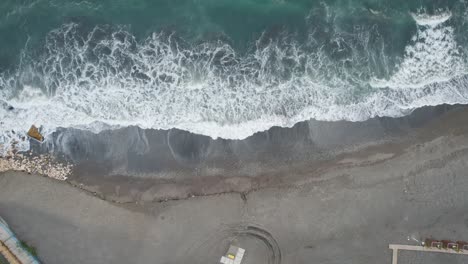 Aerial-Push-out-shot-of-a-sandy-beach-near-the-road-in-Candado,-Málaga,-Spain