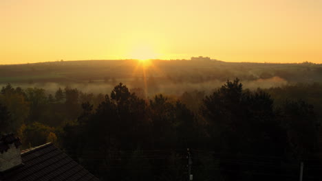 Sun-rising-in-Moldova,-drone-rising-up-reveal