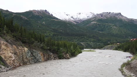 El-Río-Corre-Río-Abajo-Con-Montañas-Y-Balsas-En-Los-Fondos-En-Alaska