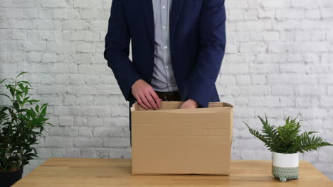 A-man-fired-from-work-is-packing-a-box-on-his-desk-and-leaving-his-job-as-unemployed