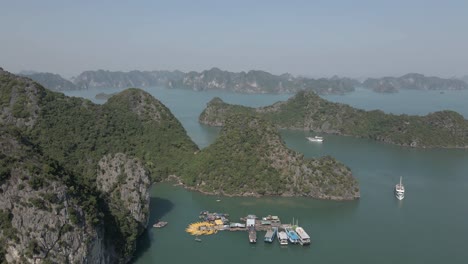 Aerial-flyover:-Tour-boats-moor-at-tourism-kayak-rental-in-Ha-Long-Bay