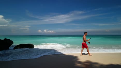 Men-on-the-beautiful-white-sand-beach,-Indonesia