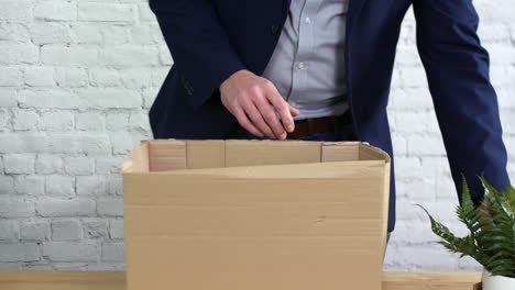 A-man-packing-a-box-on-his-desk-after-being-fired-from-work-and-is-leaving-his-job-as-unemployed