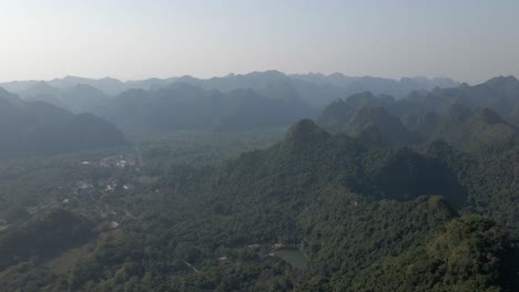 Misty-and-humid-mountain-jungle-aerial-over-Cat-Ba-Nat'l-Park,-Vietnam