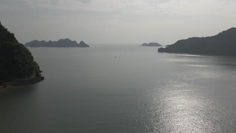 High-ocean-aerial:-Silver-sun-reflects-of-misty-water-in-Ha-Long-Bay