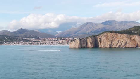 Herrliche-Landschaftliche-Aussichten-Auf-Das-Montagna-Spaccata-vorgebirge,-Motorboot-Im-Meerwasser,-Gaeta-stadt-Am-Wasser-Und-Berg-Im-Hintergrund,-Italien,-Kreisantenne