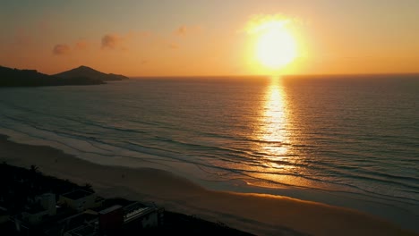 Drone-aerial-view-going-up-revealing-amazing-ocean-sunset,-South-America,-Brazil