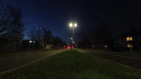 Early-morning-commuter-vehicles-headlights-passing-both-sides-of-British-highway,-Time-lapse