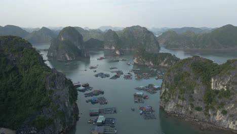 Aerial-rises-over-floating-fishing-village-ponds-and-islands,-Vietnam