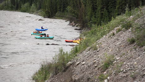 Groups-of-People-Rafting-Down-River-in-Colorful-Rafts