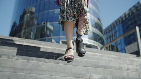 Business-woman-walking-down-the-stairs-with-a-prosthetic-leg,-businessperson-with-a-disability