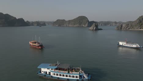 Tourists-enjoy-large-tour-boat-cruises-in-Ha-Long-Bay-Vietnam,-aerial