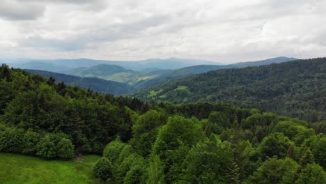 Scenic-aerial-panorama-of-Beskid-Sadecki-mountain-covered-with-forest,-Poland