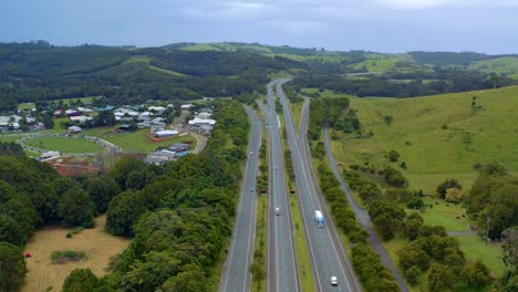 Vehicles-Driving-At-Pacific-Motorway-By-Lush-Hills-And-Fields-From-Byron-Bay-To-Brisbane-In-Queensland,-Australia
