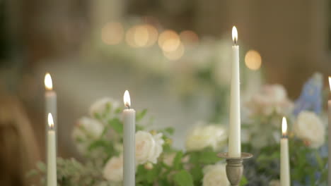 Hohe-Kerzen-Brennen-Mit-Weißen-Rosen-Im-Hintergrund