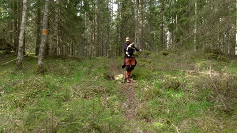 Wanderin,-Die-Vorsichtig-Einen-Hund-Auf-Dem-Wanderweg-Im-Wald-Trägt,-Zeitlupe