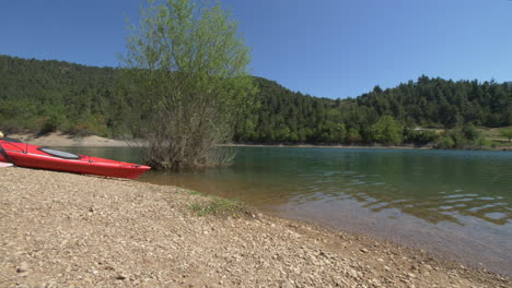 Pan-De-Kayaks-Rojos-En-La-Playa-De-Piedra-A-Lo-Largo-Del-Lago-Tsivlou-En-Grecia