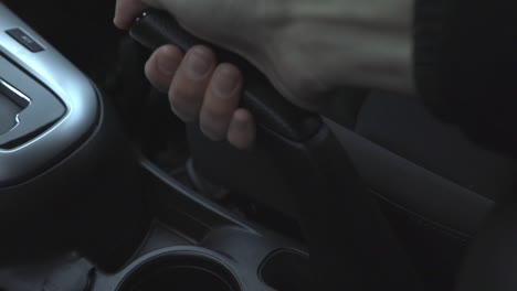 Putting-down-the-handbrake-to-drive---close-up