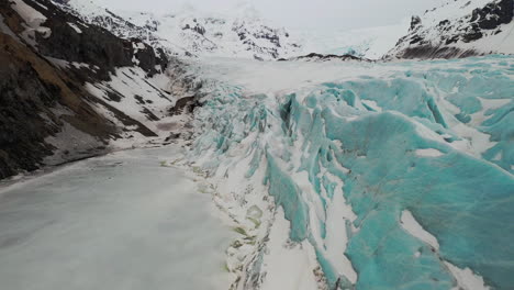 Flying-in-snow-covered-glacier-outlet-Svinafellsjökull-in-South-Iceland---Aerial-Footage
