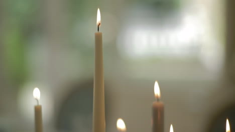 Spitze-Der-Brennenden-Kerzen-Mit-Weißen-Rosen-Im-Hintergrund