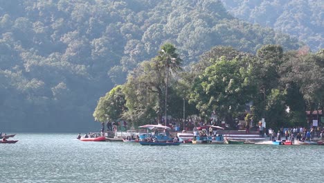 People-boating-near-the-Barahi-temple,-which-is-located-in-the-middle-of-Fewa-Lake-as-an-island