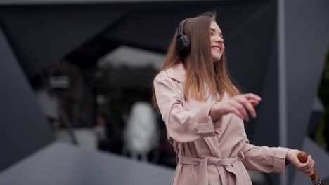 Das-Mädchen-Hört-Musik-über-Kopfhörer-Und-Tanzt-Mit-Einem-Regenschirm-In-Den-Händen