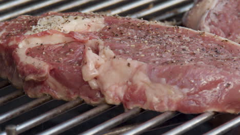 Schwenken-über-Rib-Eye-Steak,-Das-Auf-Flammendem-Grill-In-Zeitlupe-Brutzelt