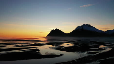 Aufsteigend-über-Dem-Wunderschönen-Sonnenuntergang-Nisten-Flüsse-Am-Brunnhorn-Berg-In-Südostisland---Luftaufstieg