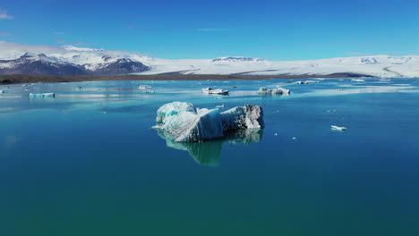 Iceberg-En-Tranquilas-Aguas-Azules-Del-Lago-Glacial-Jokusarlon---Sur-De-Islandia---Drone