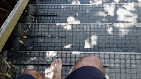 Hombre-Caminando-Descalzo-Por-Escaleras-De-Madera-Cubiertas-De-Arena-Hacia-La-Playa,-Slowmo