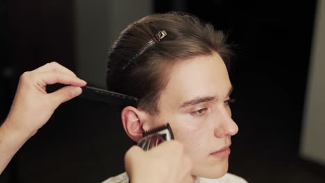 Nahaufnahmeporträt-Eines-Haarschnitts-Mit-Einer-Haarschneidemaschine-Und-Einem-Kamm-Aus-Langen-Haaren