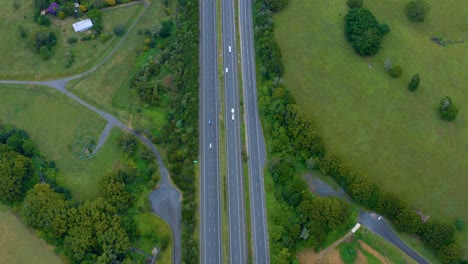 Top-View-Of-Pacific-Motorway-And-Lush-Fields,-Road-Connecting-Byron-Bay-And-Brisbane,-Australia---aerial-drone