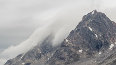 Zeitrafferansicht-Von-Wolken-Und-Nebel,-Die-über-Berggipfel-Und-Die-Hänge-Hinunterrollen