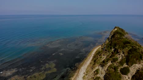 Verschmutztes-Meerwasser-Mit-Algen-Um-Den-Grünen-Hügel-Des-Kaps-An-Der-Mittelmeerküste