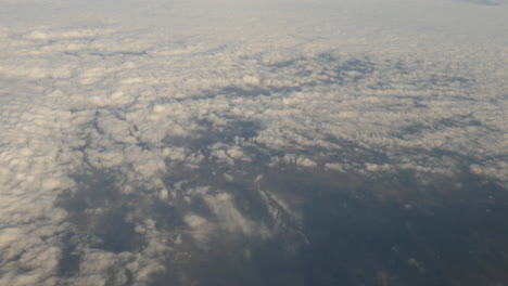 Luftaufnahme-Von-Wolken-Und-Viel-Grün-Aus-Dem-Flugzeugfenster-In-4k-Hoher-Auflösung