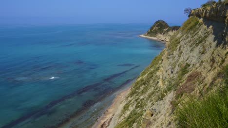 Hills-of-cape-with-sharp-slopes-surrounded-by-blue-turquoise-sea-water-on-Mediterranean-seaside