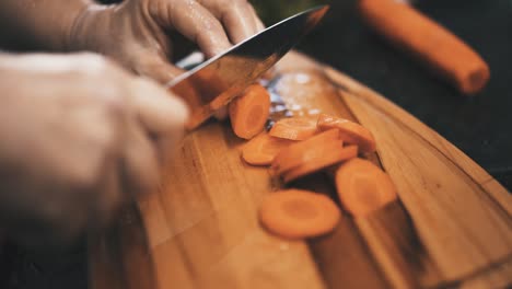 Chopping-carrots-on-wooden-board-in-slow-motion