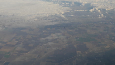 Luftaufnahme-Von-Wolken-Und-Grün-Aus-Dem-Fliegenden-Flugzeugfenster,-Aufgenommen-In-4k-Hoher-Auflösung