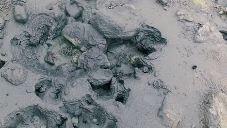 Muddy-active-bubbling-geothermal-formation-and-grey-hot-springs,-close-up-pan