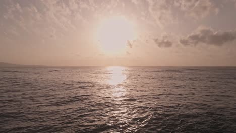 Slow-motion-shimmering-dramatic-sunset-over-peaceful-flowing-calm-ocean-waves