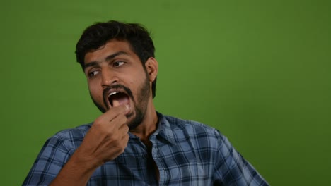 A-young-man-tired-and-yawing-in-green-screen