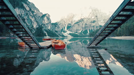 Passing-slowly-between-twin-stairs-leading-to-the-glass-like-reflections-on-Lake-Braies,-Italy,-slow-motion