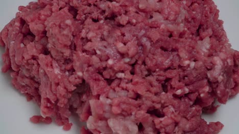 Overhead,-Rotating-Raw-Ground-Beef-Meat-on-White-Plate,-Closeup